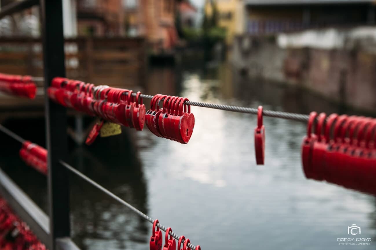 Romantik im Klein-Venedig in Frankreich: Herzschlösser an einer Brücke über dem Fluss im Stadtteil La Petite Venise
