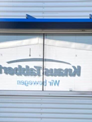 Der Schriftzug Knaus Tabbert gespiegelt in einem Fenster