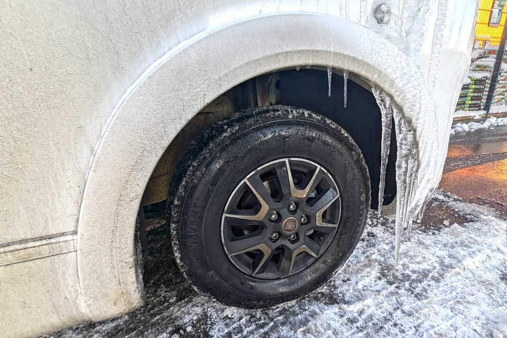 Winterreifen am Wohnmobil mit Winter-Vanlife-Eiszapfen