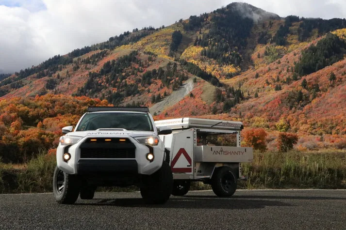 Antishanty 4XD Offroad-Trailer an einem Geländewagen vor bunten Herbstbergen