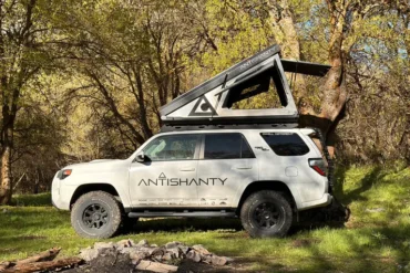 Offroad-Fahrzeug mit montiertem Roof Top Dwelling RTD in geöffnetem Zustand auf einer Wiese