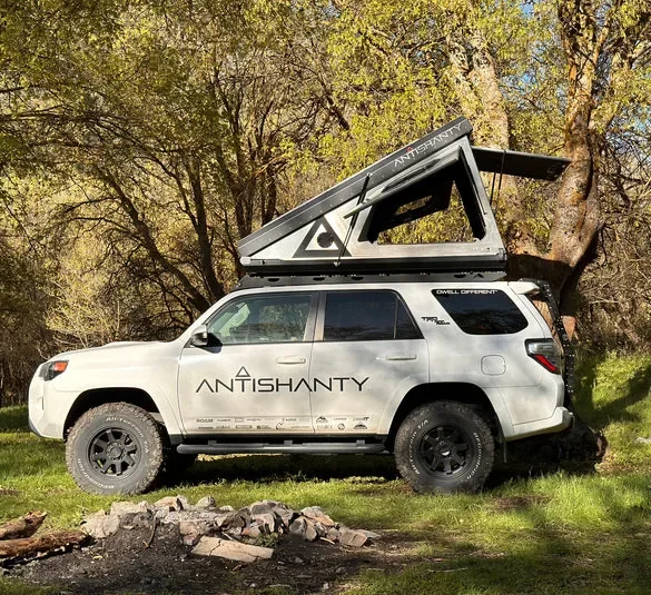 Offroad-Fahrzeug mit montiertem Roof Top Dwelling RTD in geöffnetem Zustand auf einer Wiese