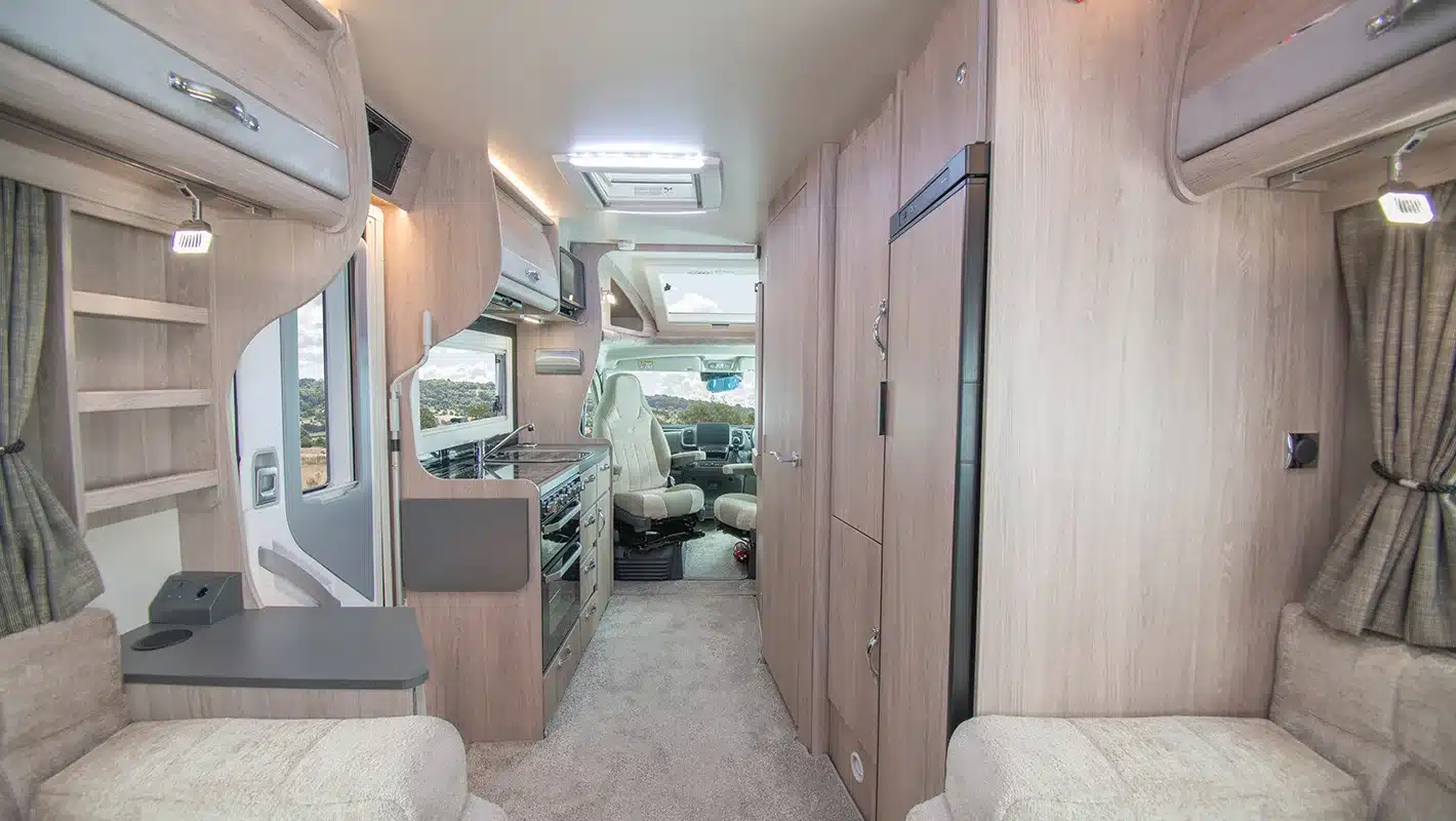 Blick in den Innenraum eines Auto-Sleepers Broadway EL Wohnmobils mit Küche, Sitzbereich und Fahrerhaus