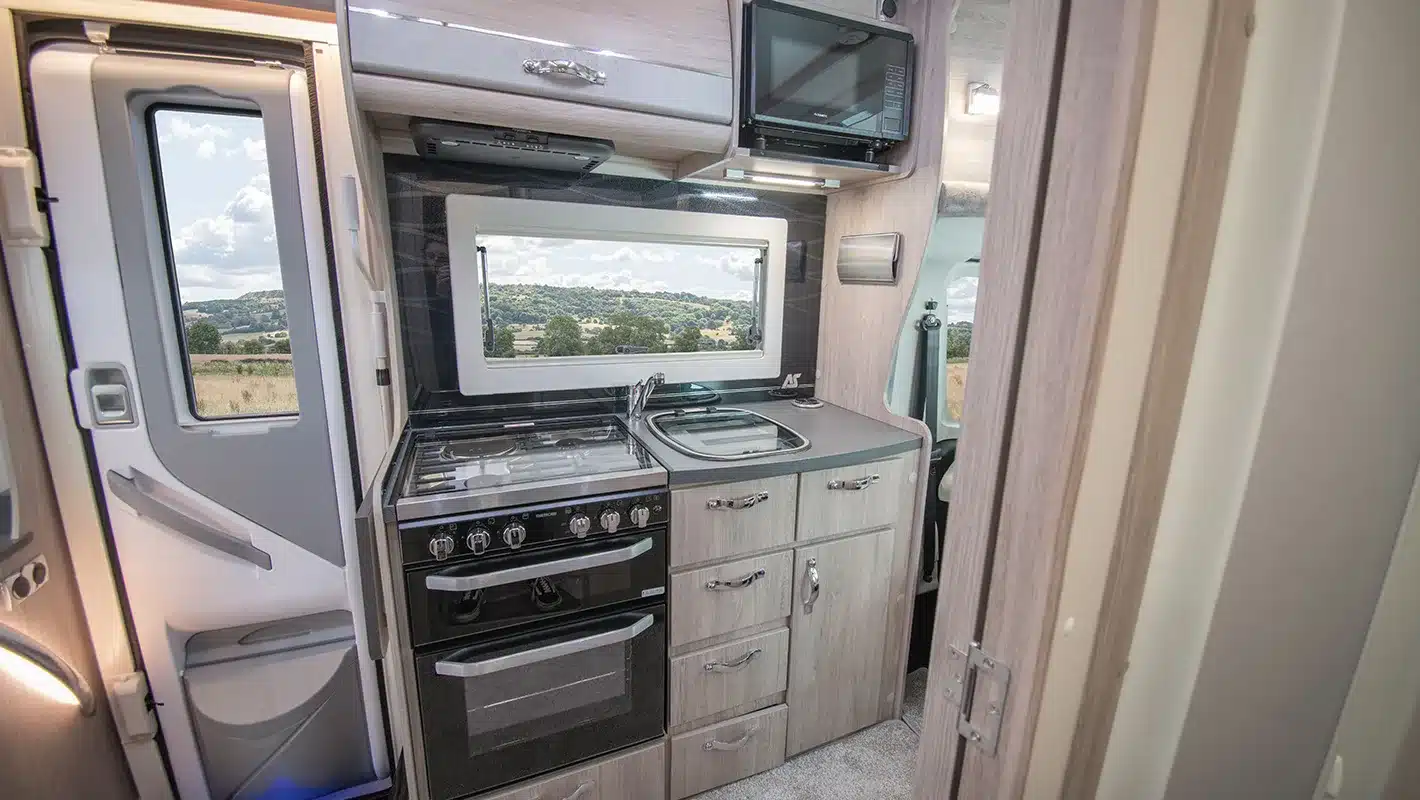 Küchenbereich mit Herd, Backofen, Spüle und Mikrowelle im Auto-Sleepers Broadway EL Wohnmobil