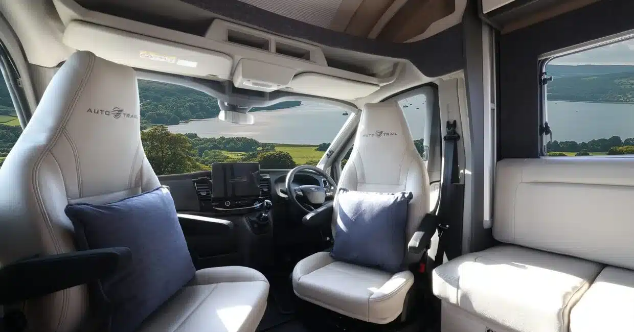 Blick in das Fahrerhaus und den Wohnbereich eines Auto-Trail F-Line F60 mit zwei drehbaren Sitzen und großem Fenster