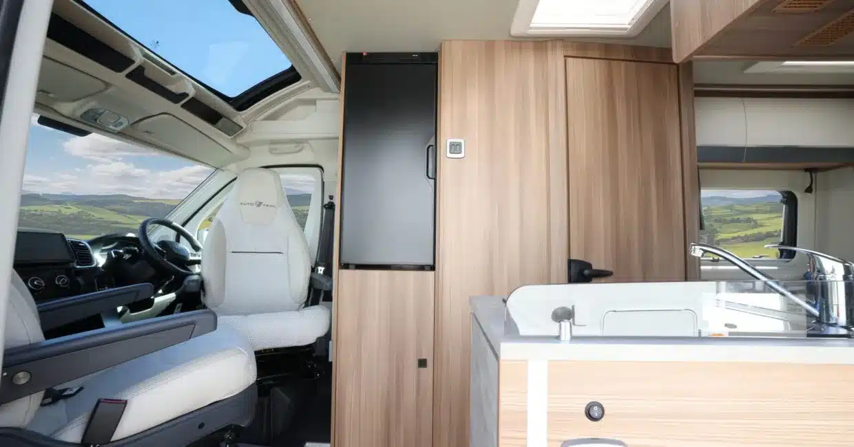 Blick in den Innenraum eines Auto-Trail V-Line 540 SE Campervans mit Fahrersitz, Küchenzeile, Holzdekor und großem Dachfenster