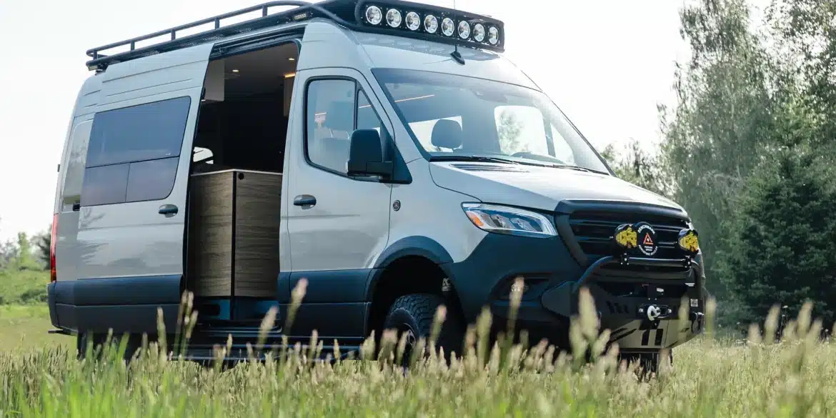 Benchmark CUBMOBILE 2024, ausgebauter Mercedes Sprinter 144 AWD mit Offroad-Komponenten und geöffnetem Seiteneingang auf einer Wiese