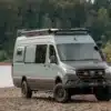 Mercedes Sprinter 170 EXT Allrad Benchmark Es-Cap-Aye Offroad-Campervan auf Schotterpiste am Flussufer