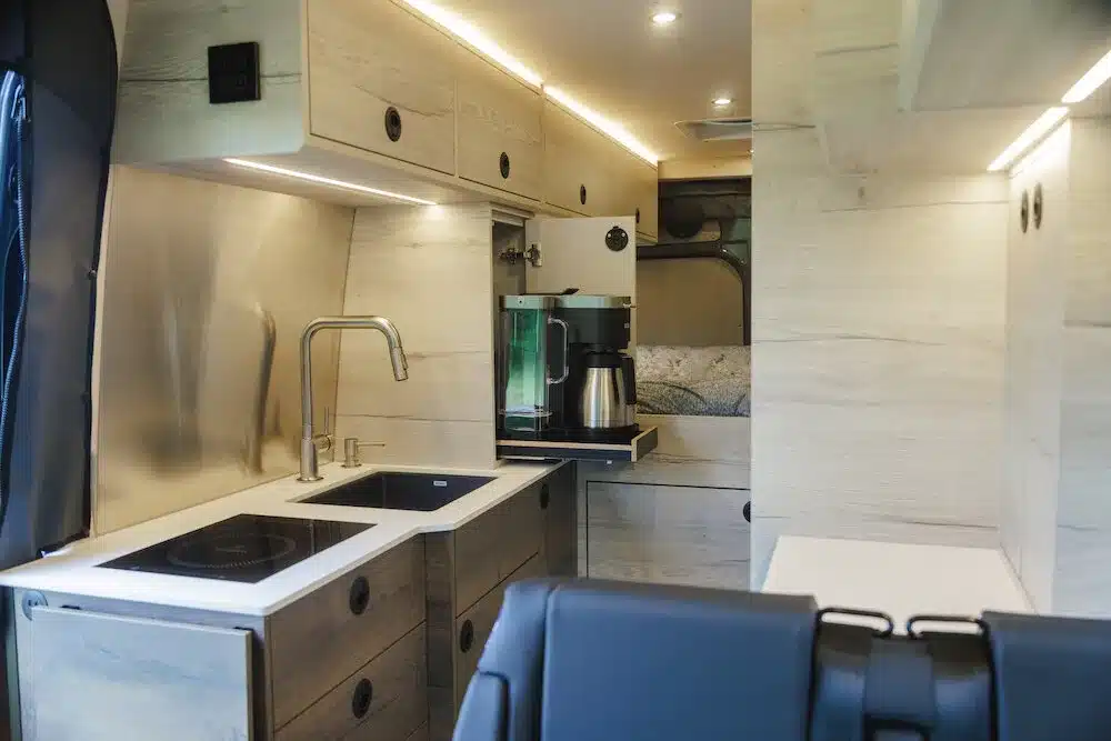 Innenansicht des Benchmark Paradise Vans mit moderner Küchenzeile, Stauraum und Sitzbereich