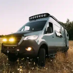 Benchmark Pronto 4x4 Mercedes Sprinter Campervan mit Offroad-Umbau und Lichtsetup auf einer Wiese
