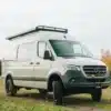 Mercedes Sprinter 144 4x4 Benchmark Sahara Campervan auf Feldweg mit Dachträger und Markise