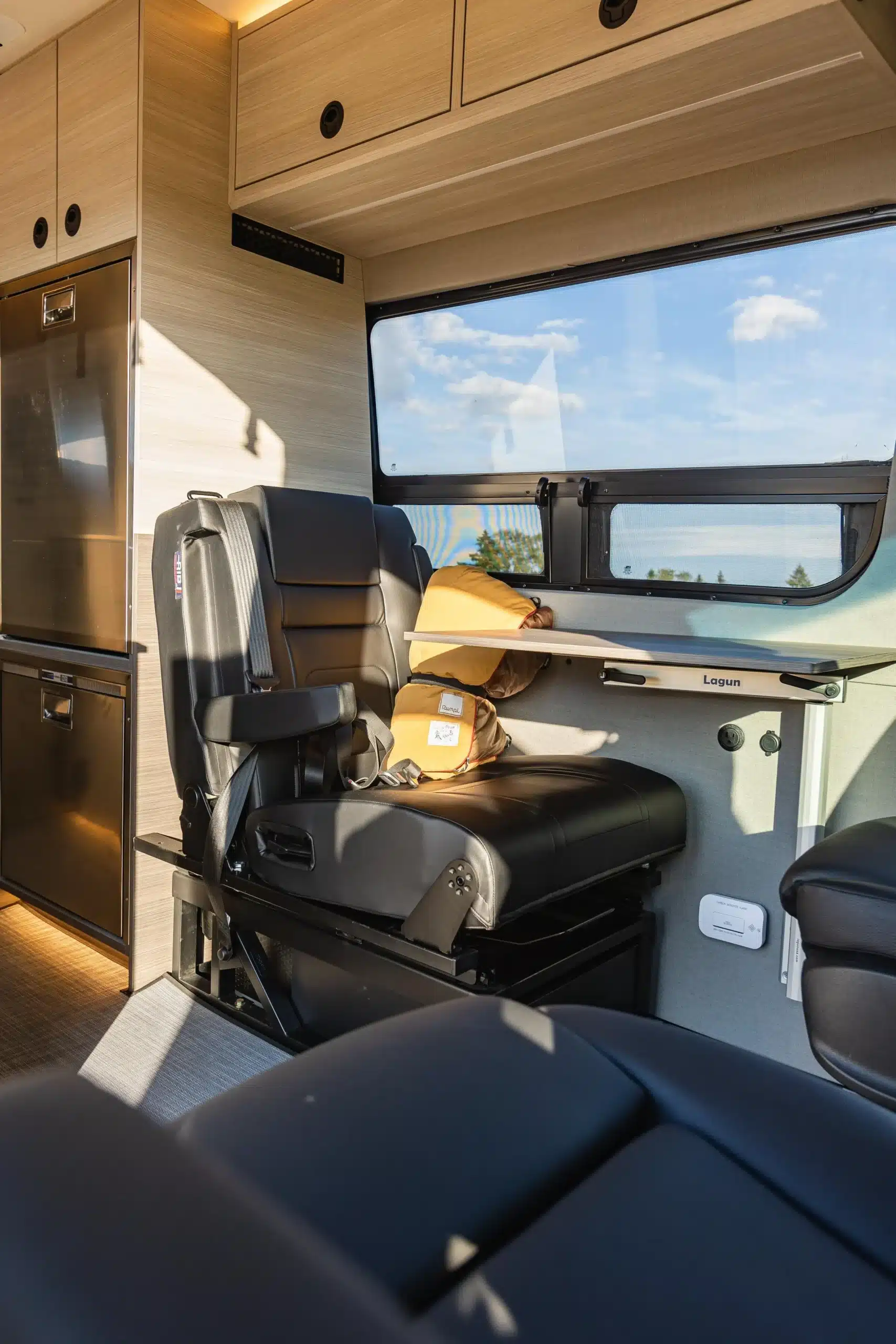 Hochwertiger Sitzbereich mit Tisch und Stauraum im Innenraum eines Benchmark Vehicles Codigo Azul Campervans