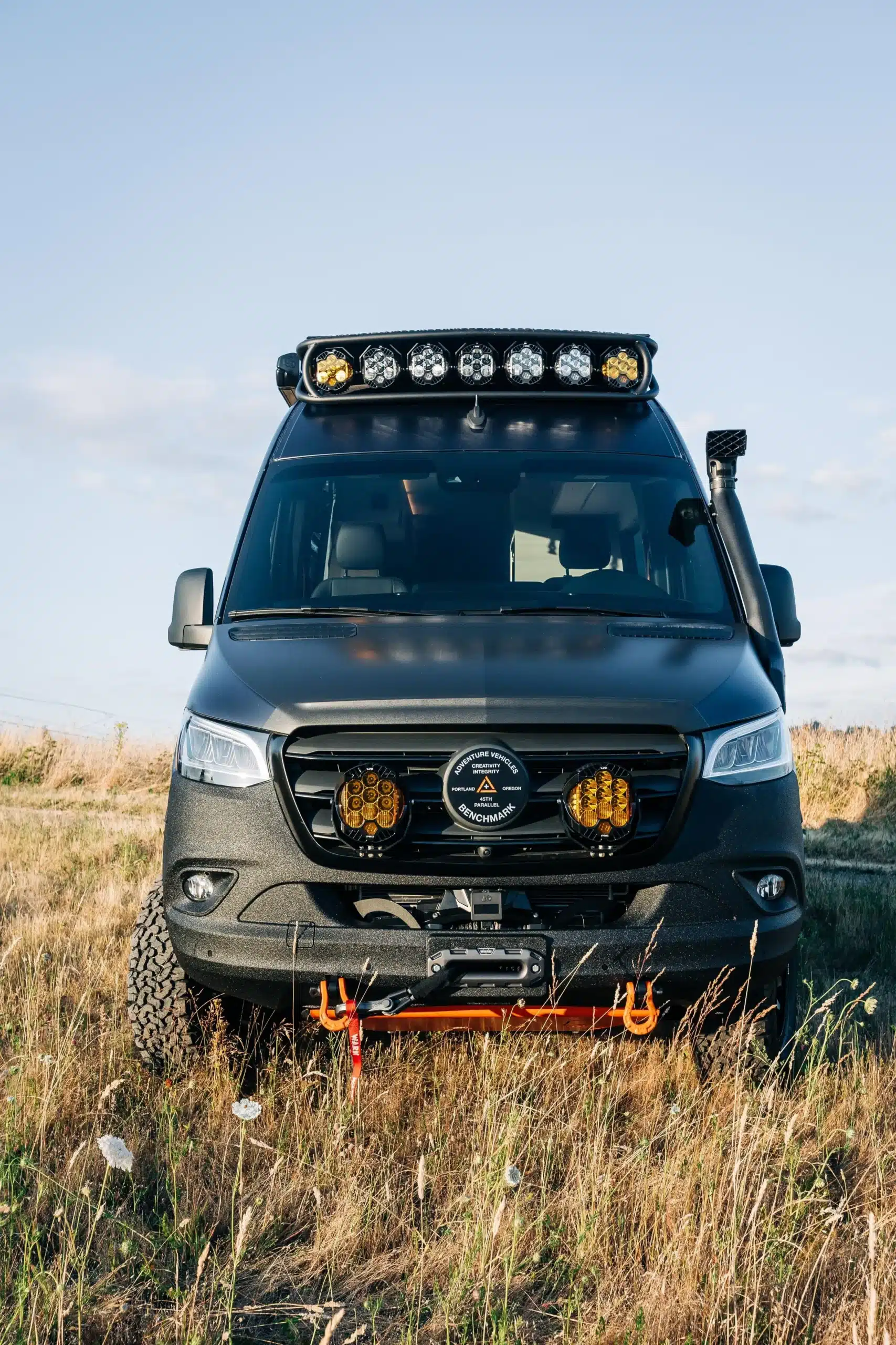 Frontansicht eines Benchmark Vehicles Codigo Azul Adventure-Campers mit Offroad-Ausstattung auf einer Wiese