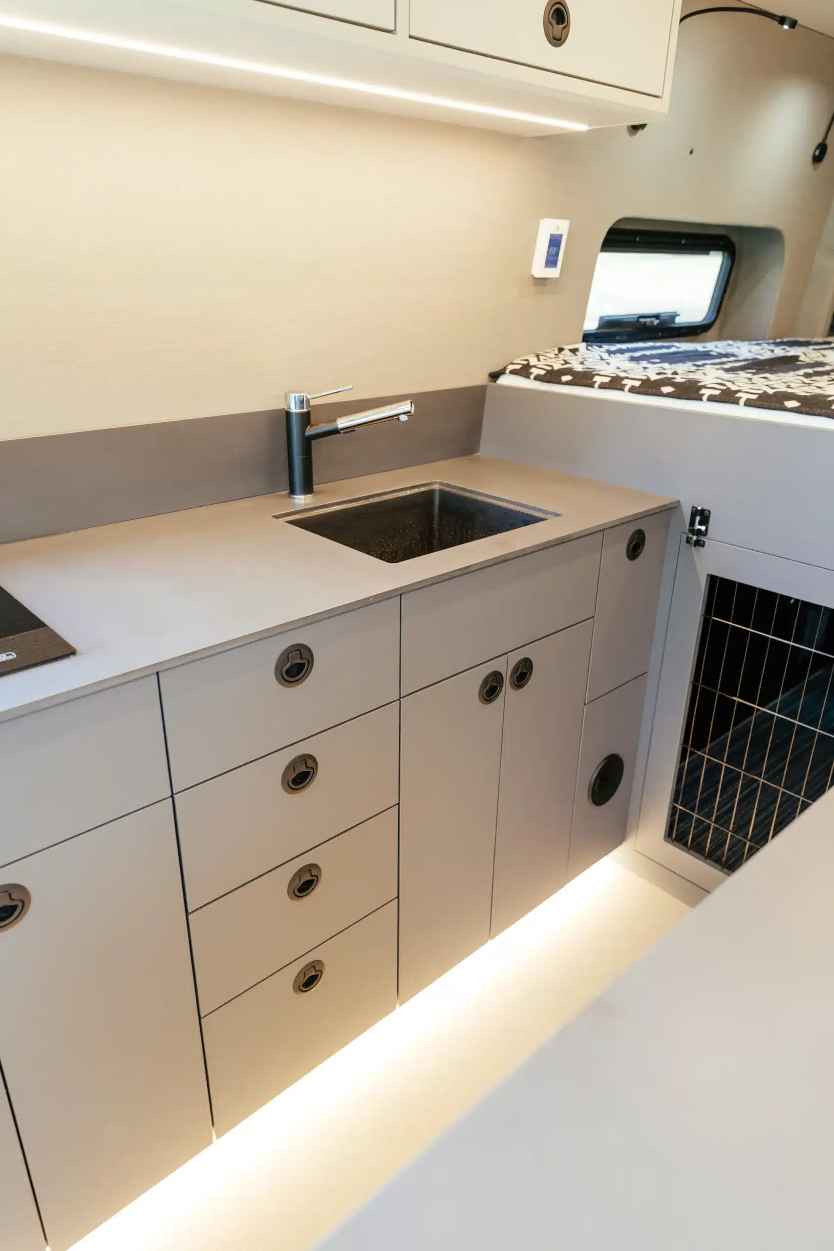 Innenansicht der Küchenzeile mit Spüle, Stauraum und Hundebox im Campervan Lucky auf Basis eines Mercedes-Benz Sprinter 170 4x4