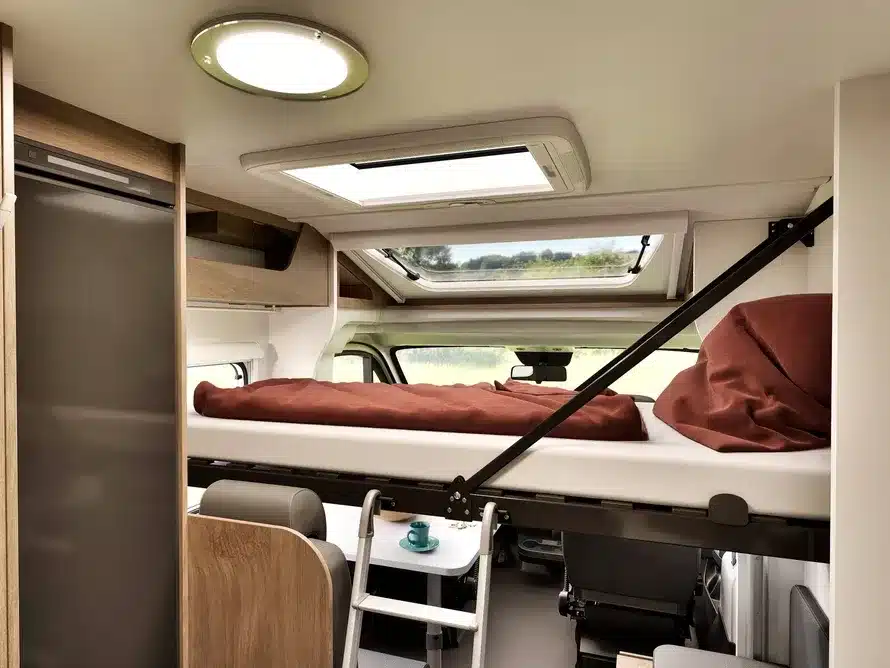 Innenansicht des Carado V347 mit abgesenktem Clever-Lift-Bett über der Sitzgruppe