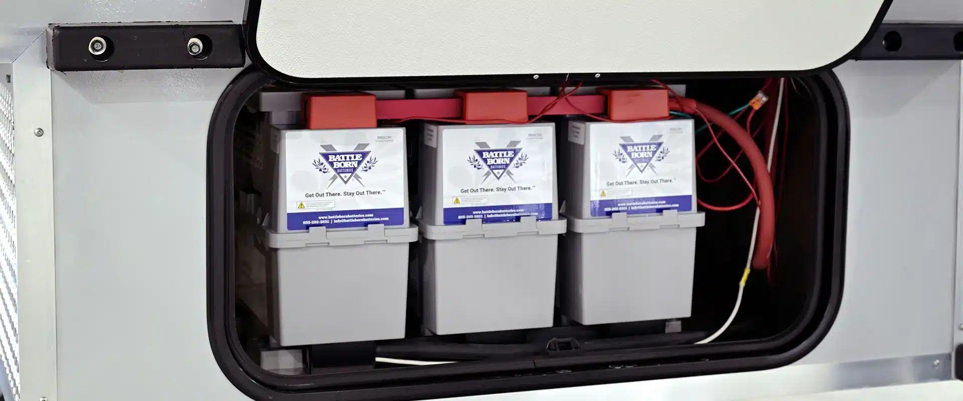 Drei Battle Born Lithium-Batterien in einem Staufach des Cirrus 920 Truck Campers