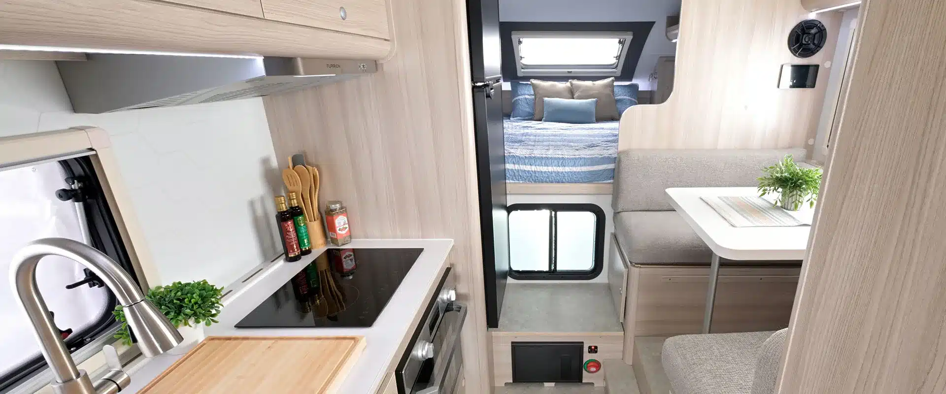 Blick in den Innenraum des Cirrus 920 Truck Campers mit Küche, Sitzgruppe und Schlafbereich