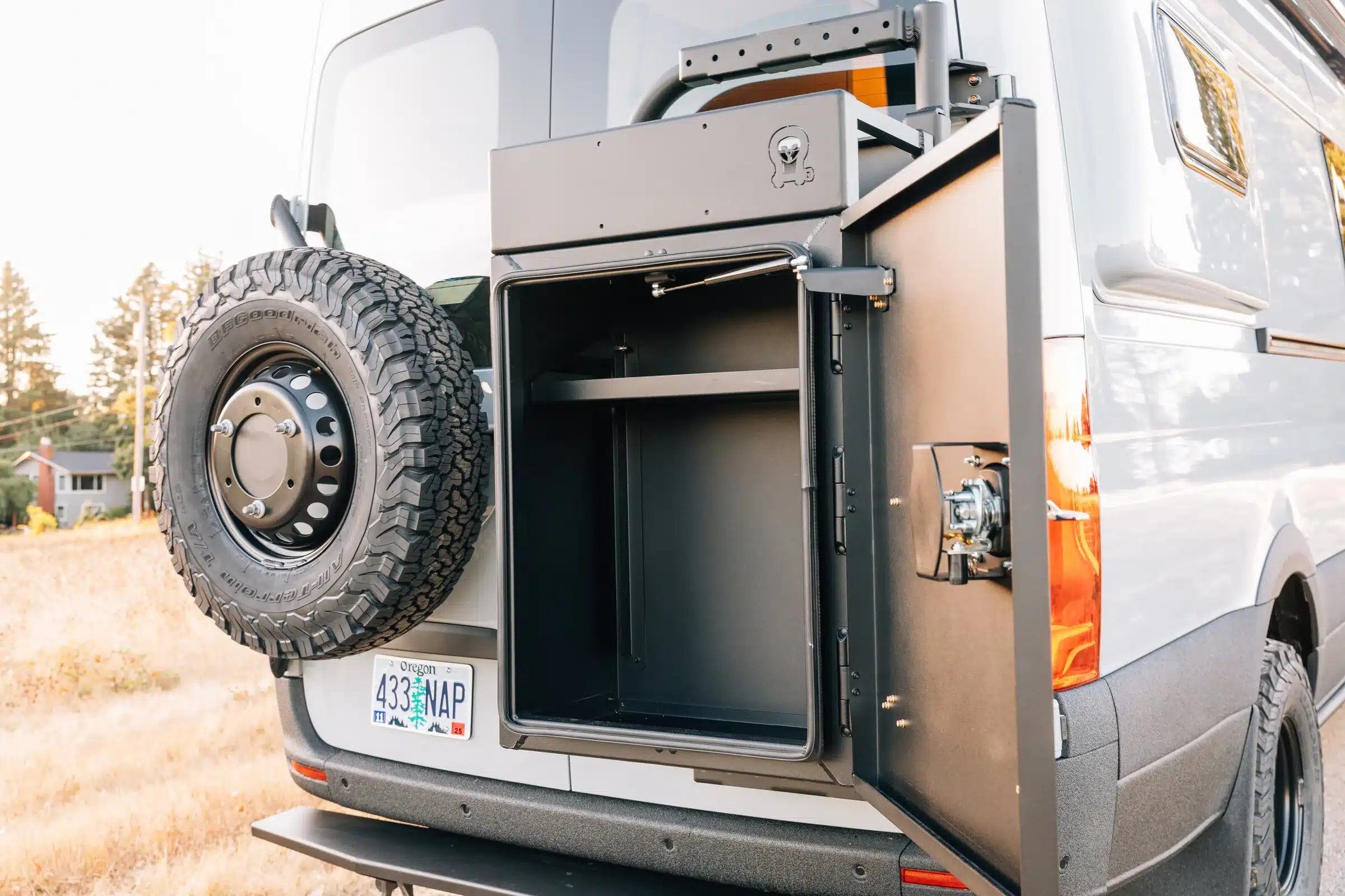 Geöffneter Waffenschrank am Heck eines Mercedes Sprinter 4x4 Condor mit montiertem Ersatzrad