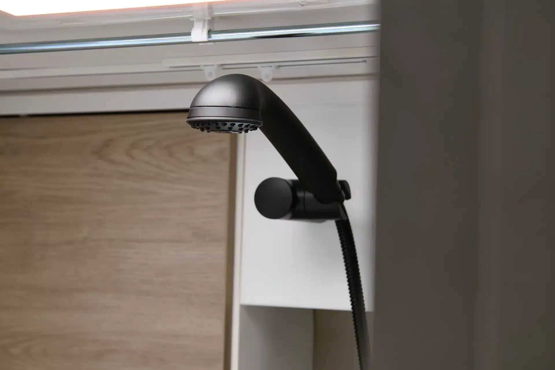 Nahaufnahme eines schwarzen Duschkopfs im Badezimmer des CROSSCAMP ADVTR 6.4 EF