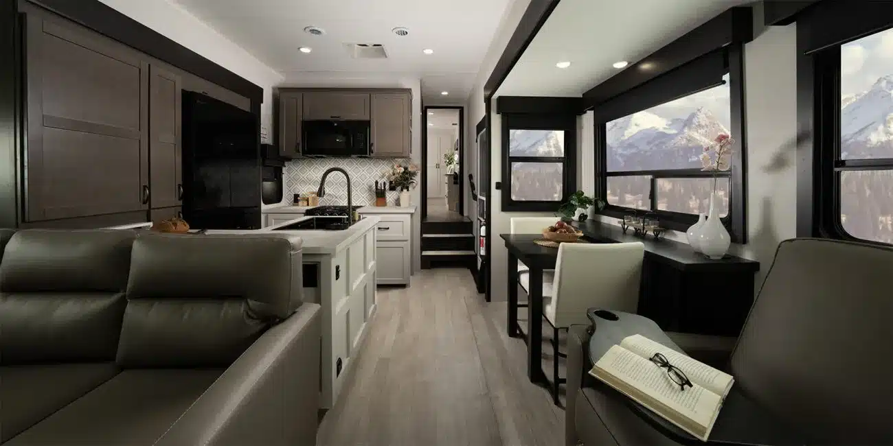 Innenansicht eines Cyclone Fifth Wheel Toy Hauler mit moderner Küche, Essbereich und großen Fenstern mit Bergblick
