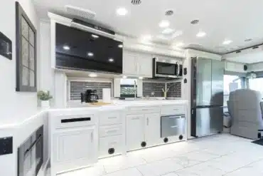 Helle, moderne Küche mit großen Schränken, Spüle, Mikrowelle, Kühlschrank und TV im Berkshire 39A Wohnmobil