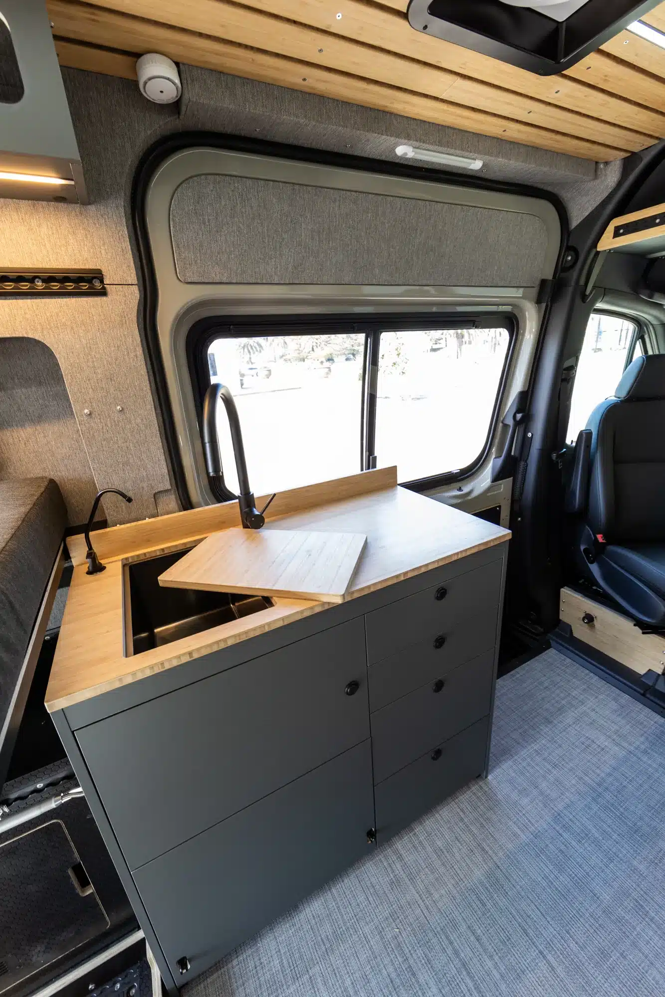 Innenansicht der Küchenzeile mit Spüle und Stauraum im Summit M1 Van auf Mercedes-Benz Sprinter Basis