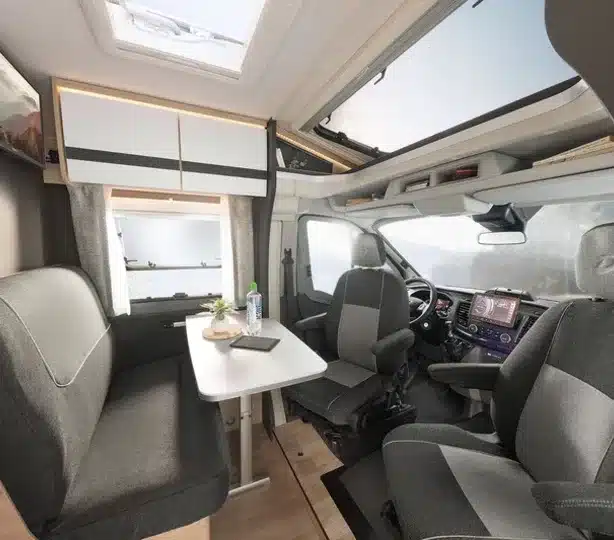 Innenansicht des Dethleffs Globebus Go Active mit Sitzgruppe, Tisch und Fahrerhaus