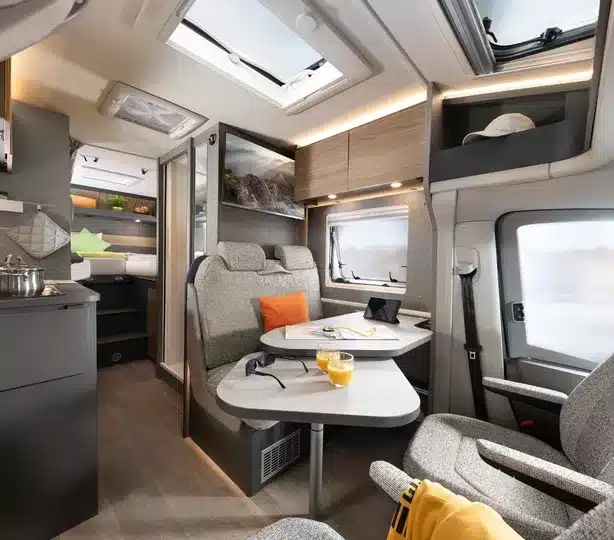 Blick in den Innenraum des Dethleffs Globebus Performance 4x4 mit Sitzgruppe, Tisch, Küchenzeile und Schlafbereich