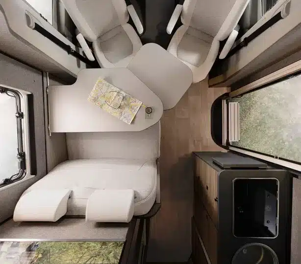 Blick von oben auf den Wohnbereich des Dethleffs Globebus Performance 4x4 mit Halbdinette, schwenkbarem Tisch und Küchenzeile