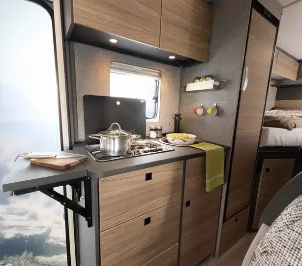 Küchenbereich im Dethleffs Globebus Performance 4x4 mit Kochfeld, Arbeitsfläche und Holzdekor