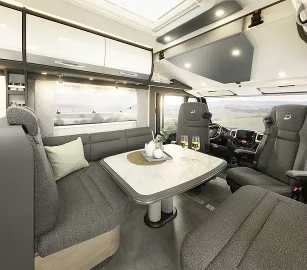 Wohnbereich des Dethleffs Globetrotter XL I mit großer Sitzgruppe, Tisch und Panoramawindschutzscheibe
