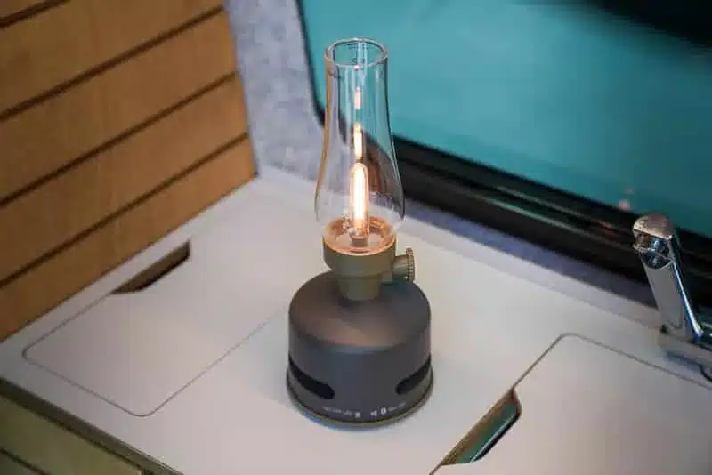 MoriMori LED-Leuchte mit Glas-Lampenschirm und Bluetooth-Lautsprecher auf einer Campervan-Oberfläche
