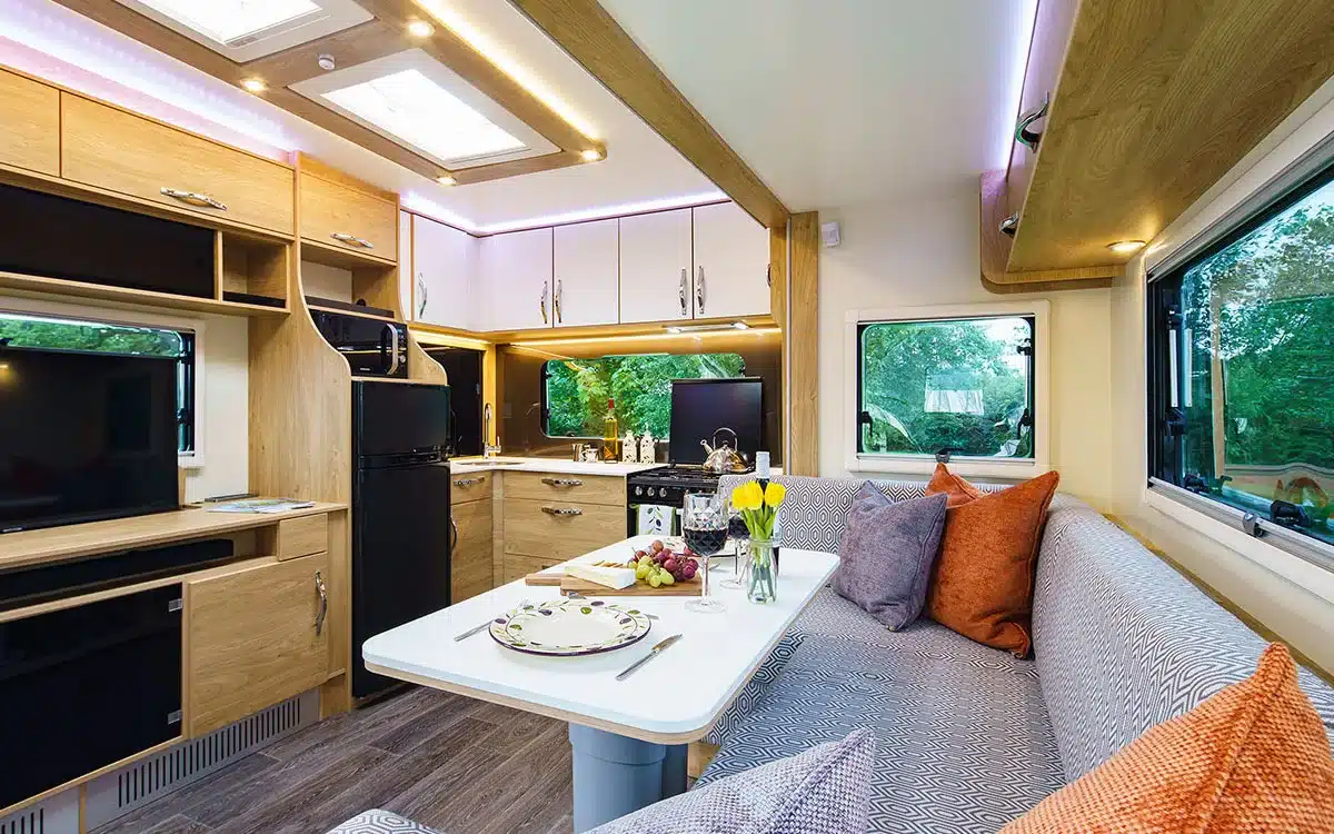 Innenraum des Dreamseeker Fifth Wheel Caravan mit moderner Küche, Sitzgruppe, Esstisch und großen Fenstern