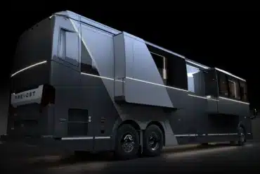 Seitenansicht eines Elite H-Series Motorhomes auf Prevost H3-45 Chassis mit ausgefahrenen Slide-Outs und LED-Lichtakzenten bei Nacht