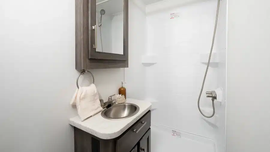 Waschbecken, Spiegelschrank und Dusche im Badezimmer eines Entegra Coach Esteem XL Super-C-Reisemobils