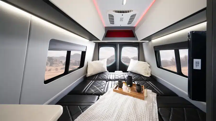 Moderner, hochwertig ausgestatteter Innenraum eines Entegra Insignia Executive Vans mit schwarzem Leder, Ambientebeleuchtung und Ausblick auf eine Wüstenlandschaft