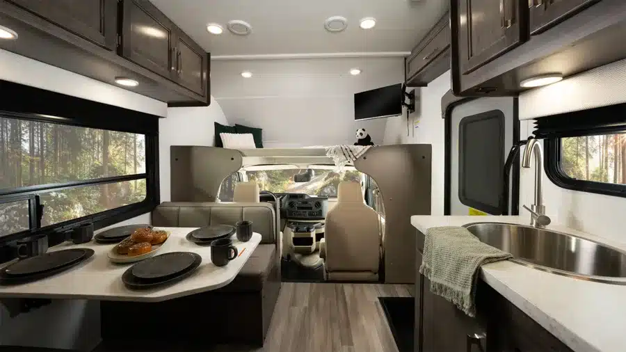 Innenansicht eines Entegra Odyssey SE mit Sitzgruppe, Küche, Alkoven und Fahrerhaus.