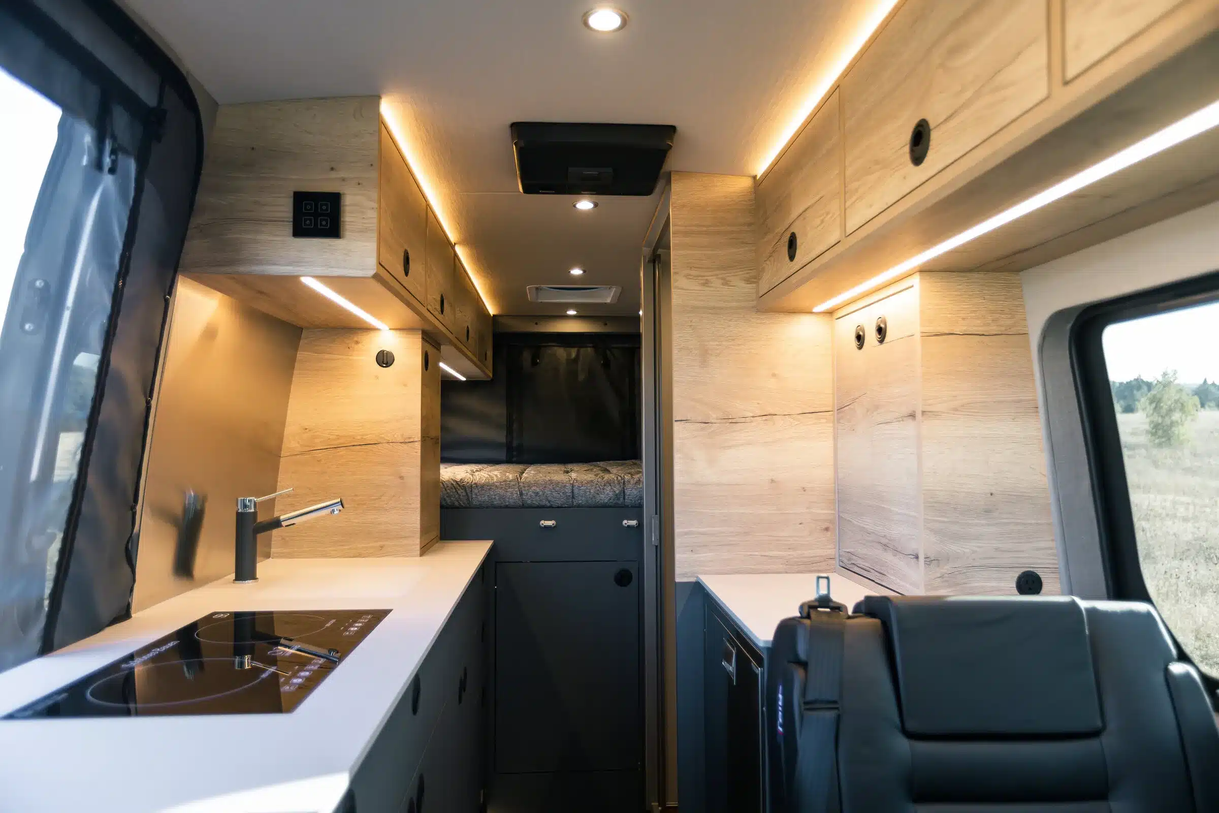 Innenansicht eines Eskadi 4x4 Sprinter Vans mit moderner Küchenzeile, Stauraum und Schlafbereich