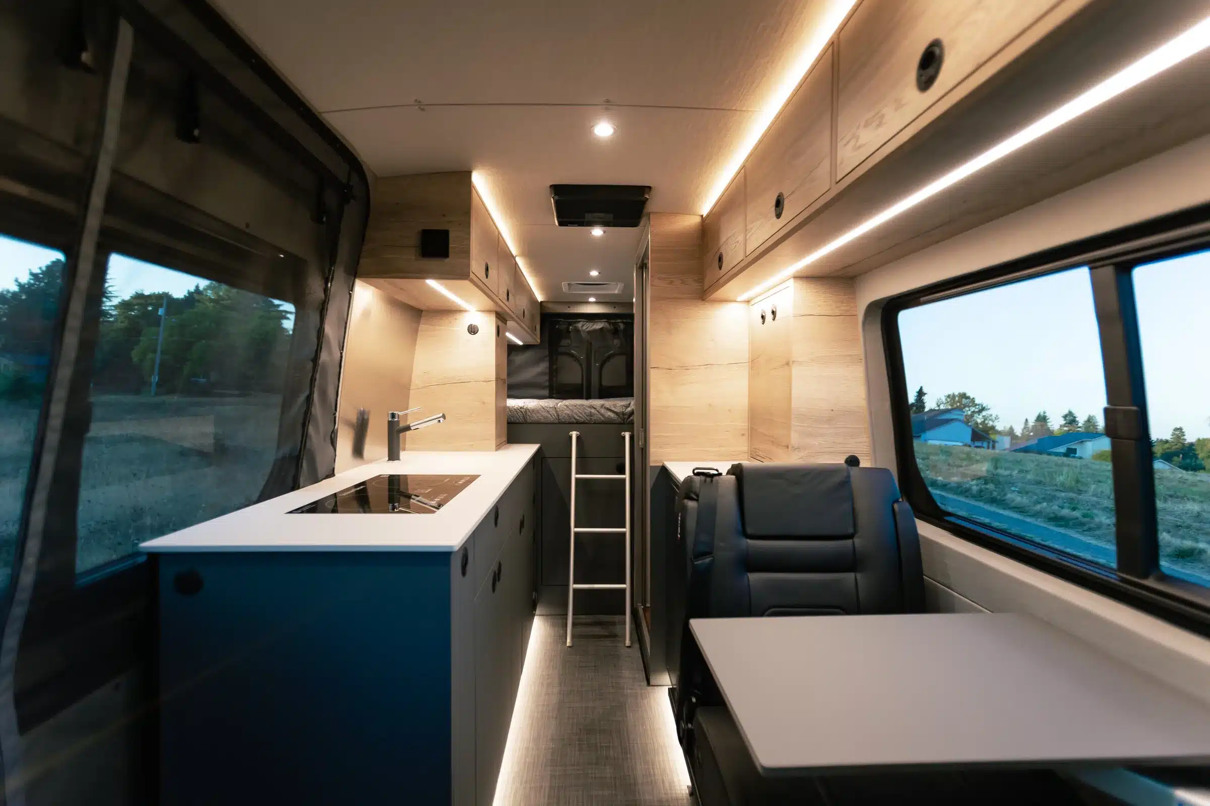 Innenansicht eines Eskadi 4x4 Sprinter Vans mit moderner Küche, Sitzgruppe und Schlafbereich