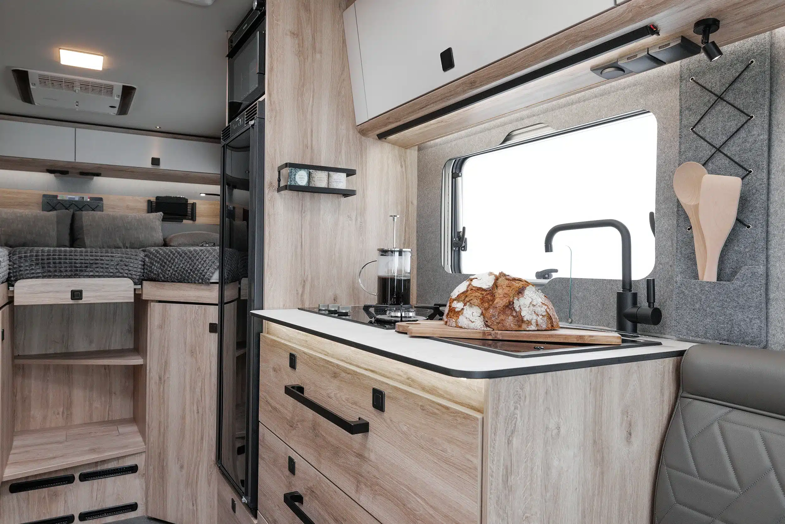 Küche und Wohnbereich im Eura Mobil Xtura 4x4-Fernreisemobil mit Brotlaib auf dem Schneidebrett