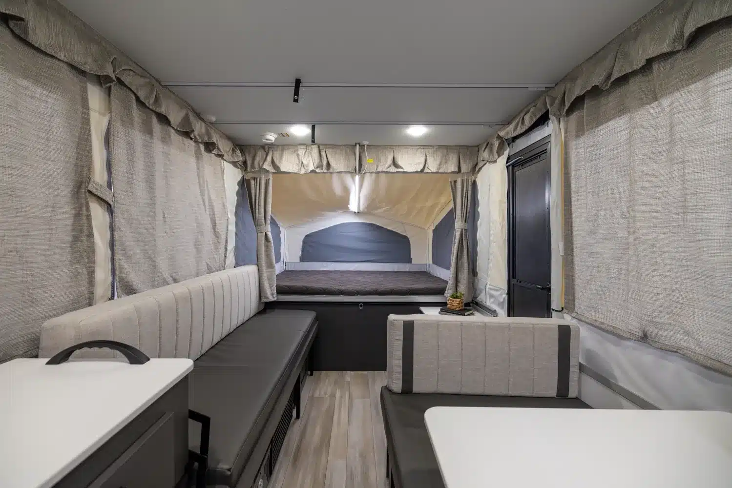 Innenansicht eines Flagstaff Tent Zeltcampers mit Sitzbank, Tisch und ausgezogenem Schlafbereich