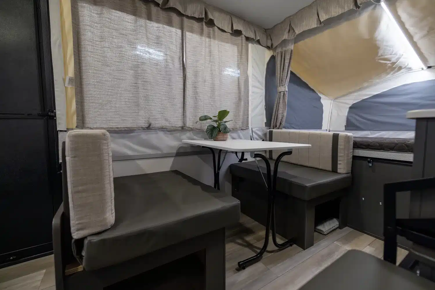 Innenansicht eines Flagstaff Tent Zeltcampers mit Sitzgruppe, Tisch und Polsterbänken