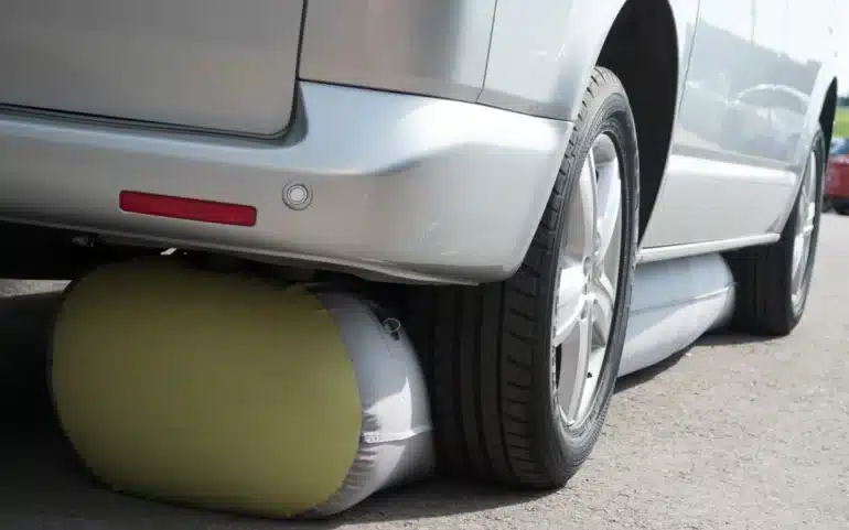 Detailaufnahme einer aufblasbaren Bodenschürze GentleTent Seal Tube, die unter einem silbernen Wohnmobil montiert ist