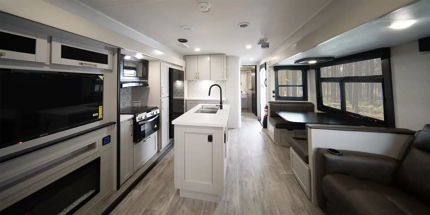 Blick in den hellen, modernen Innenraum eines Heartland 31BROK Travel Trailers mit Küche, Esstisch und Sitzgelegenheiten