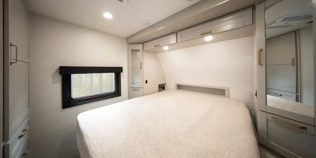 Innenansicht des Schlafzimmers im Heartland 31BROK Travel Trailer mit großem Bett, Schränken und Fenster