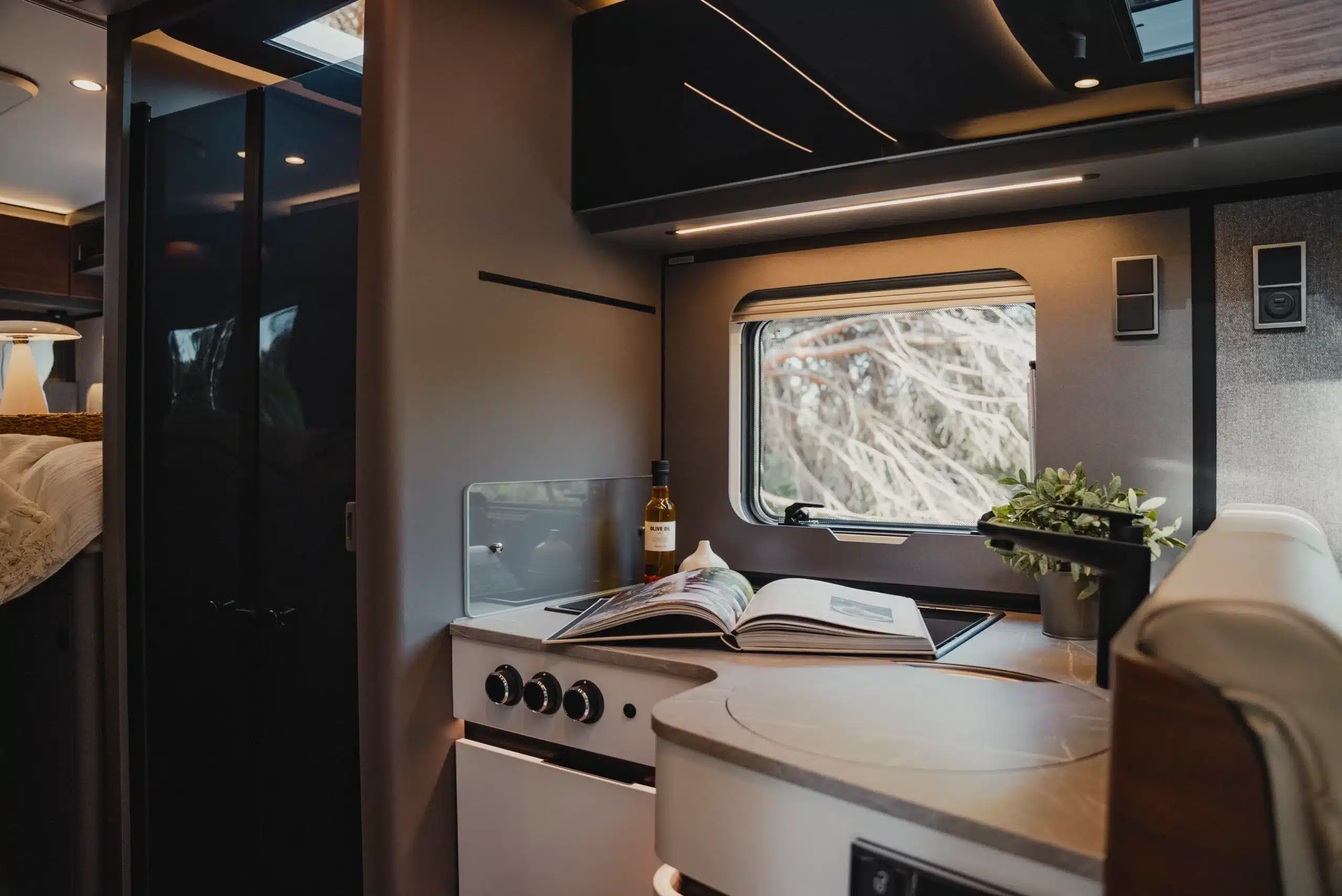 Küchenbereich im HYMER B-Klasse ModernComfort T mit Herd, Arbeitsfläche, Fenster und Dekoration