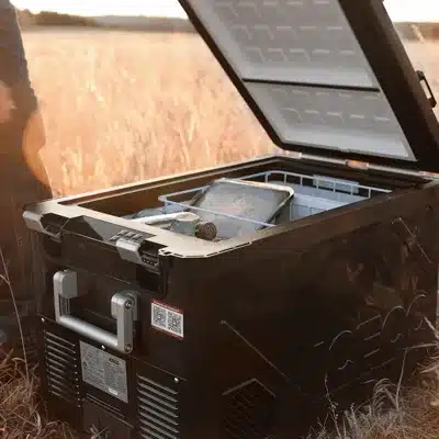 Geöffnete ICECO APL55 Kompressor-Kühlbox Dual Zone im Feld, befüllt mit Lebensmitteln