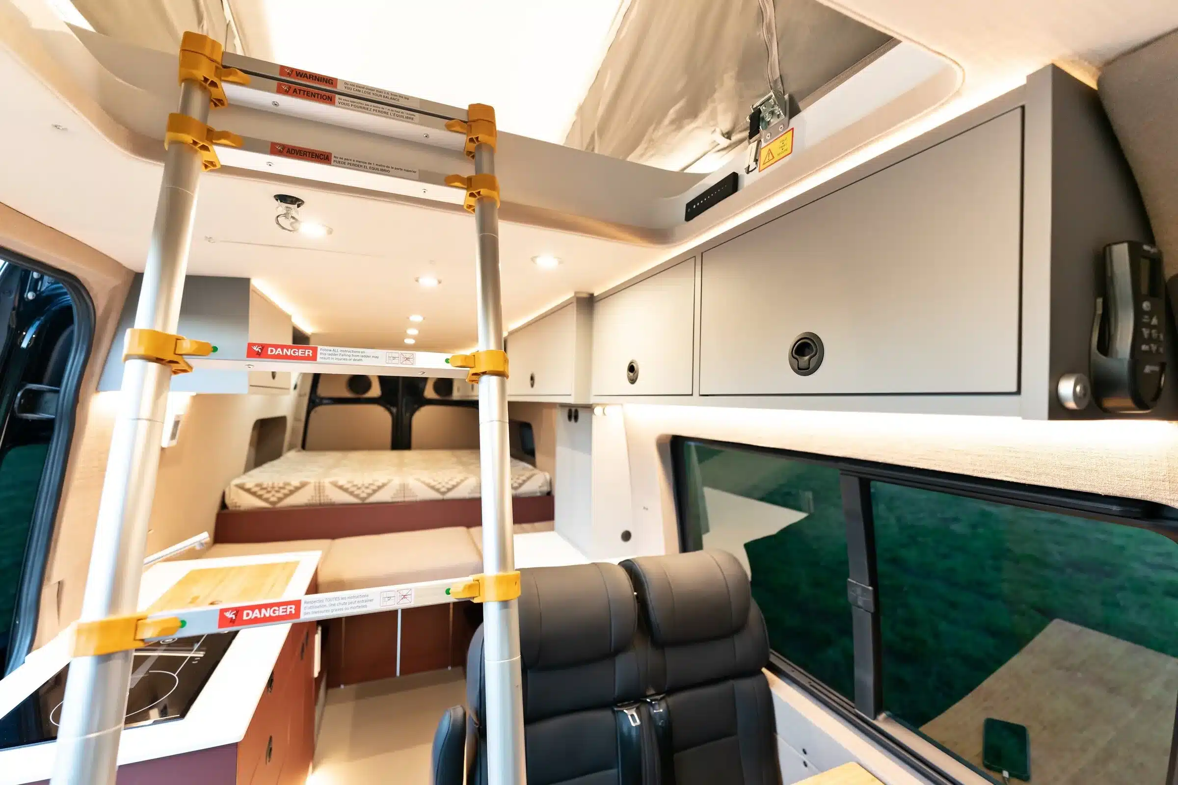 Innenansicht des Leithaus-Ausbaus im Mercedes Sprinter 170 4x4 mit Leiter zum Aufstelldach, Schlafbereich, Küche und Sitzgruppe
