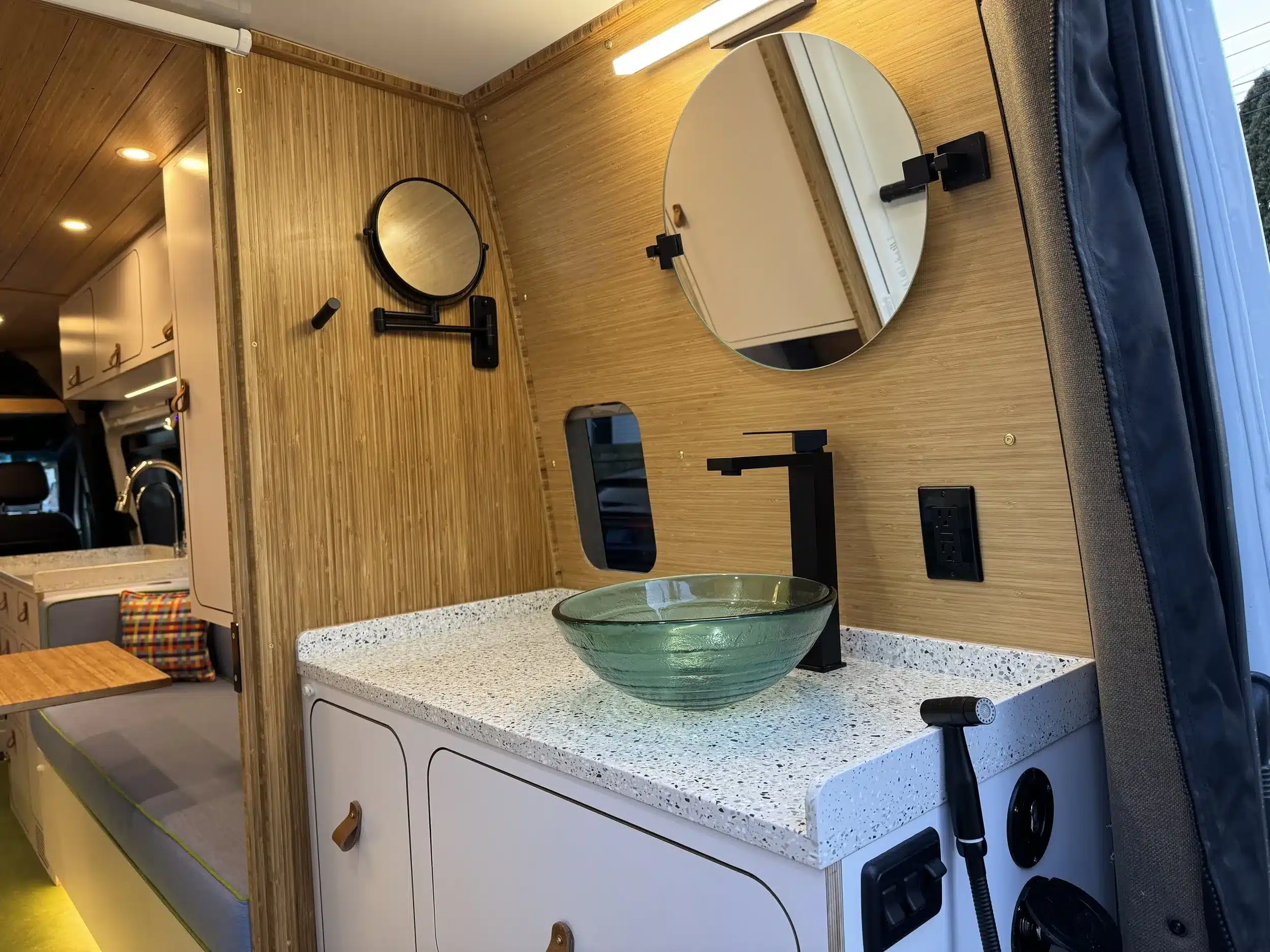 Waschbereich mit Glaswaschbecken, Spiegel und moderner Armatur im Campervan Linda Lou