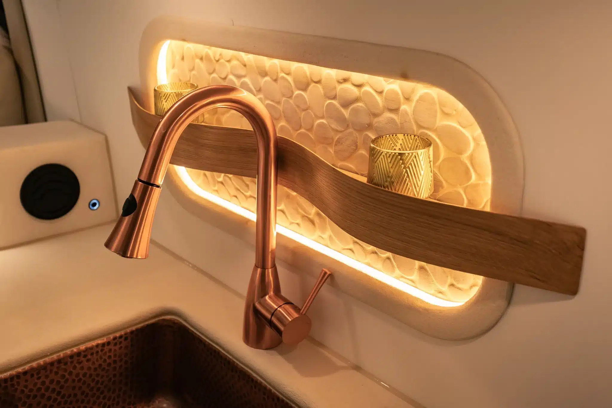 Kupferfarbene Küchenarmatur und beleuchtetes Steinmosaik im Luna Van von Rogue Vans